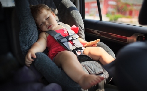 Bambino che dorme in auto